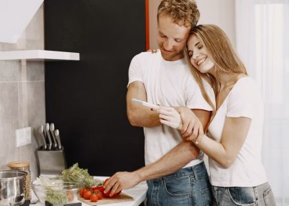 Happy couple celebrating a positive pregnancy test result in their kitchen, embracing the joyful moment together.